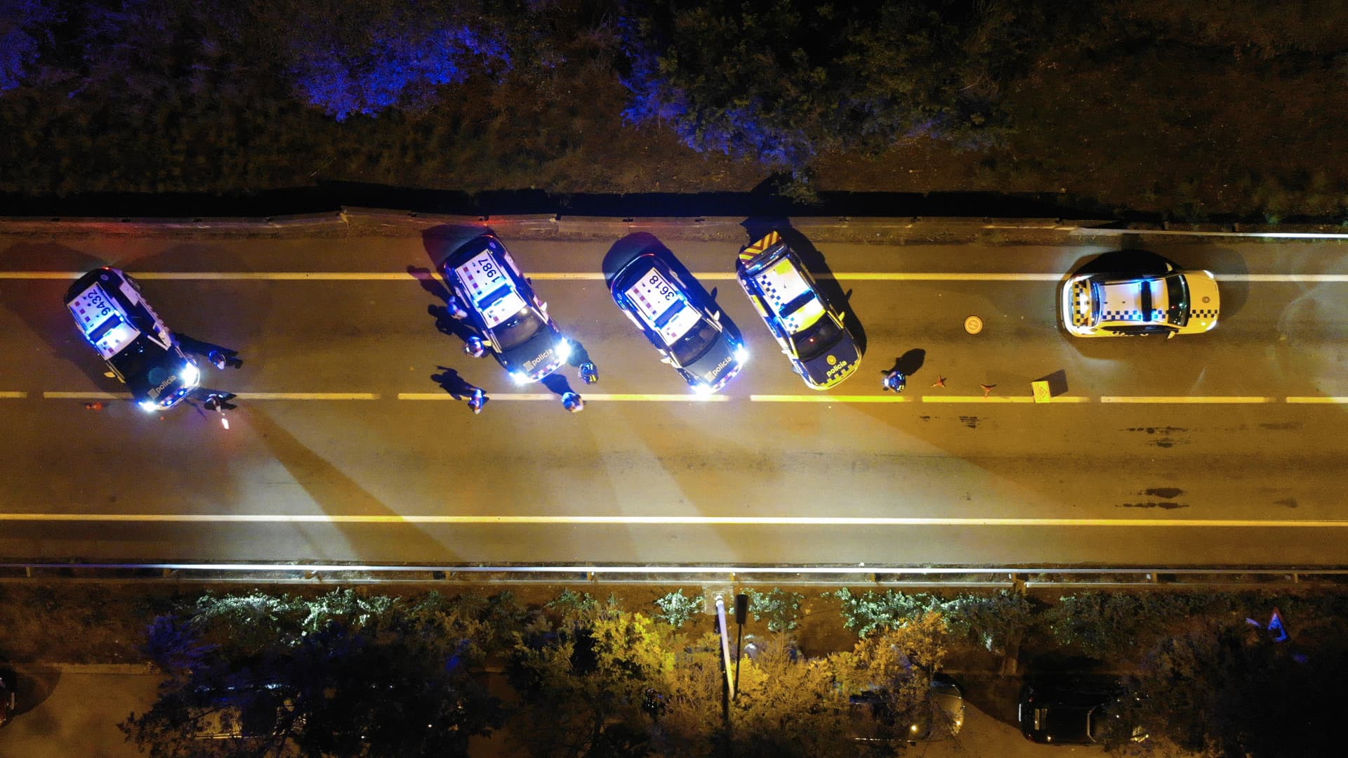 Formadors ensenyant a un grup d'agents de policia com realitzar un control de pas a la via pública.